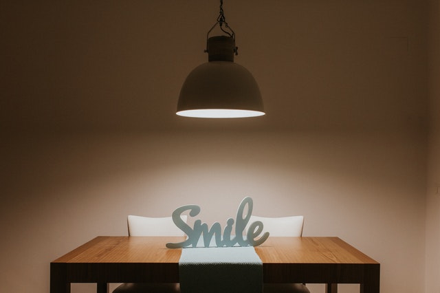 Lampa svieti na drevený stôl s nápisom úsmev.jpg